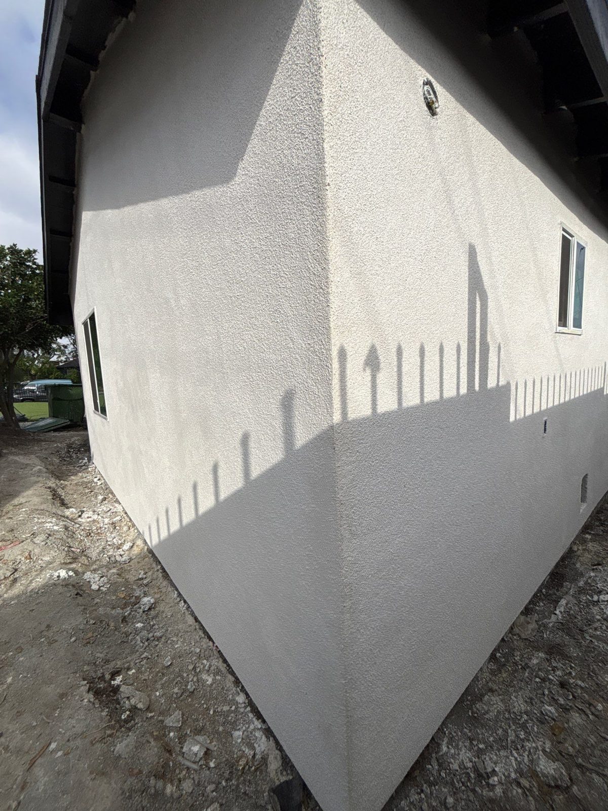 Finished sand-finish stucco on the corner of a house